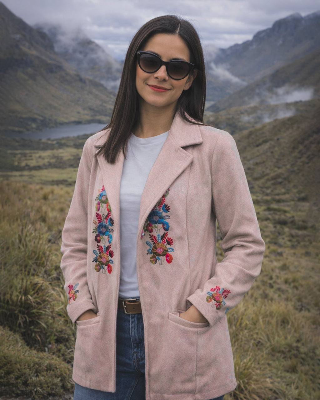 Mujer con gafas de sol y el Abrigo Jardín rosa claro con flores bordadas, con las manos en los bolsillos