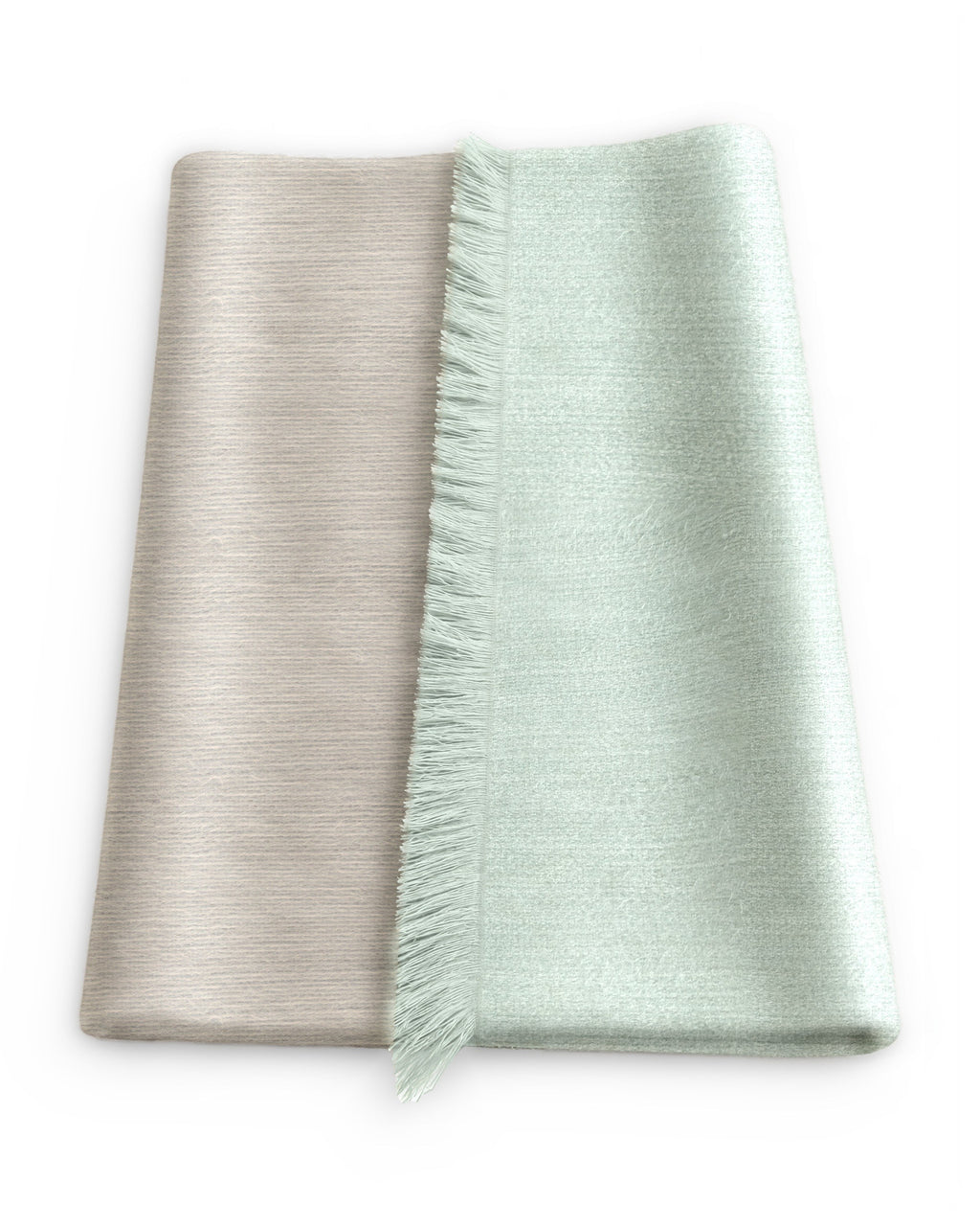 Chal de alpaca doble cara Salvia doblado sobre una mesa, con un lado verde salvia claro y el otro beige tostado