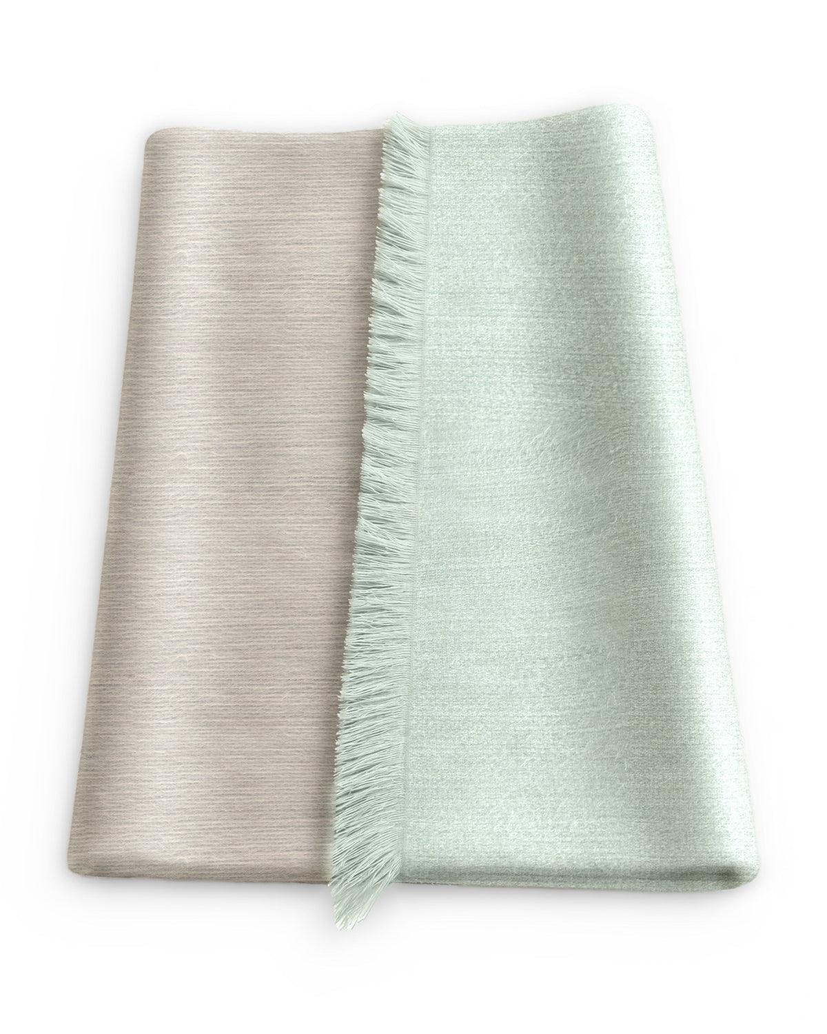 Chal de alpaca doble cara Salvia doblado sobre una mesa, con un lado verde salvia claro y el otro beige tostado