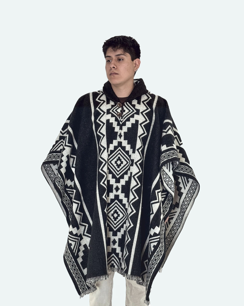 Hombre de tres cuartos mirando de lado con el poncho Chimborazo negro con rombos crema