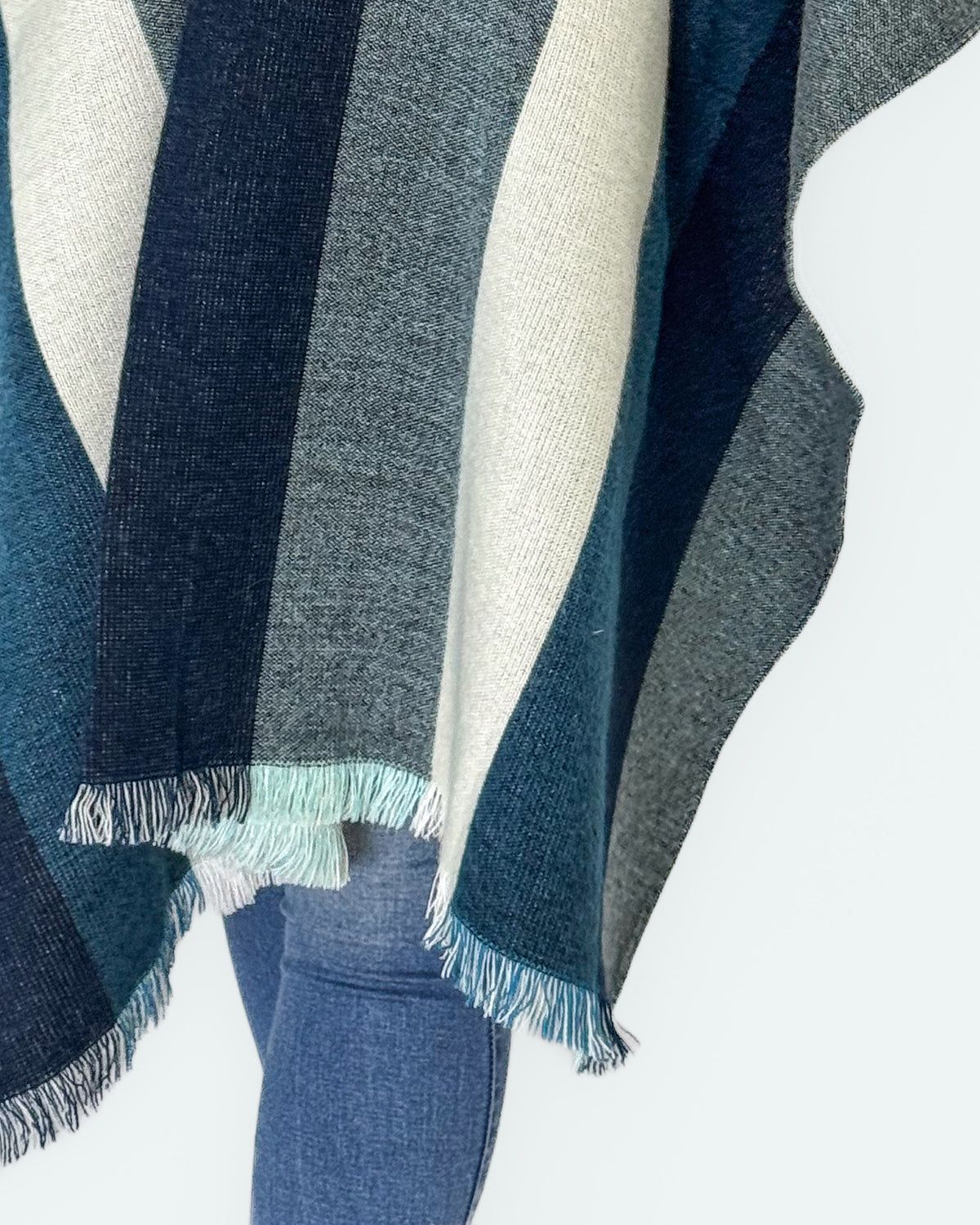 Detalle de los flecos celestes y blancos y las franjas azules y crema del borde del poncho Cuicocha
