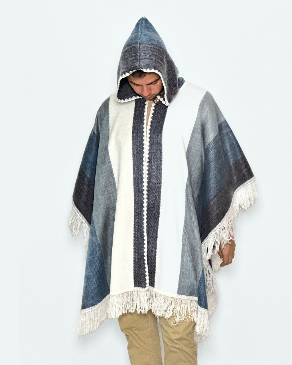 Hombre con la capucha puesta y la mirada hacia abajo con el poncho Espíritu Cielo Andino