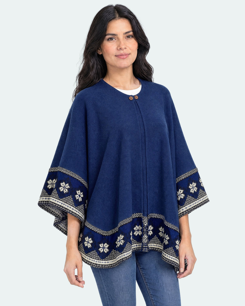 Mujer con el Poncho Flor de Imbabura azul profundo y mangas anchas, toma de tres cuartos