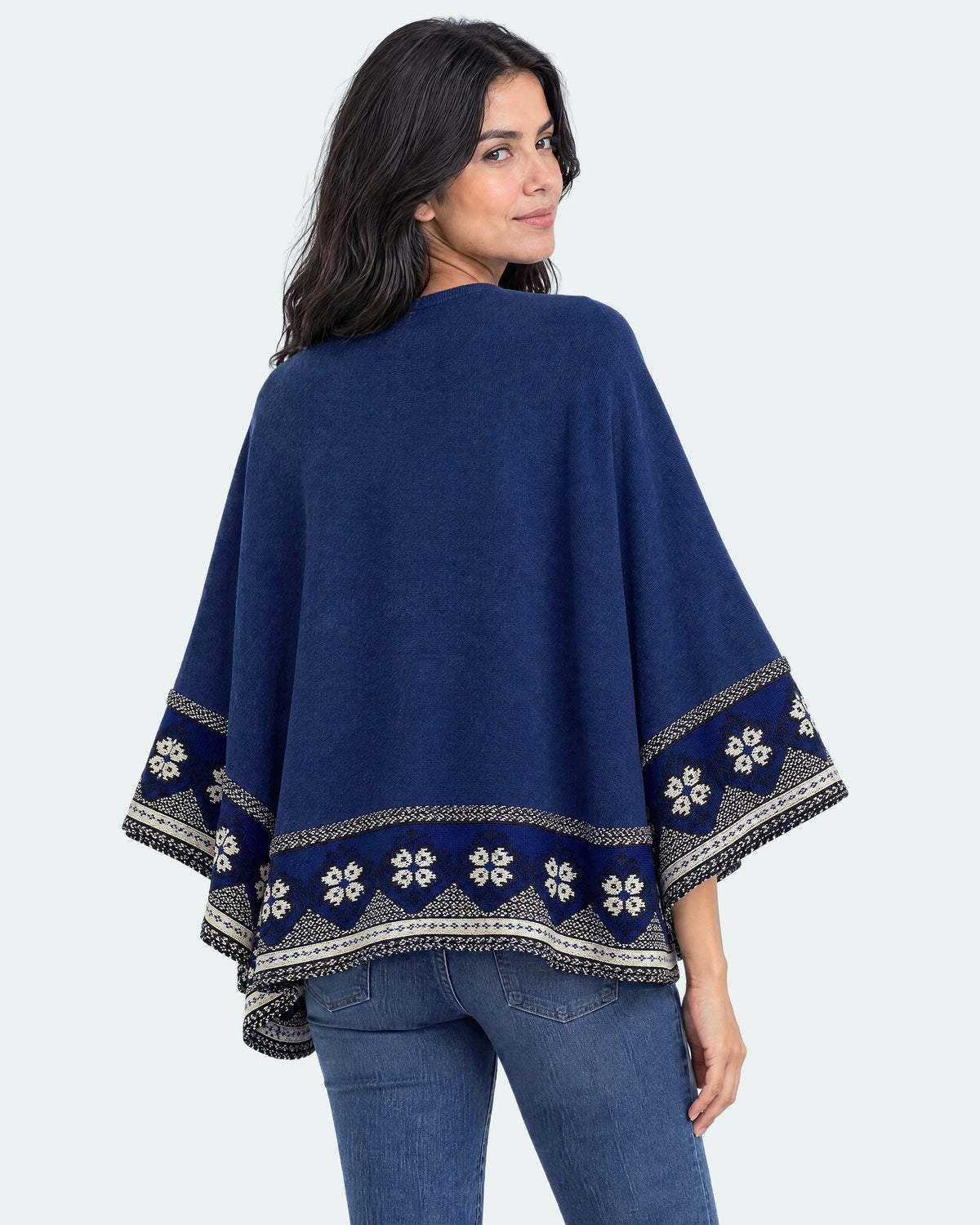 Mujer mirando sobre el hombro con el Poncho Flor de Imbabura azul visto de espalda