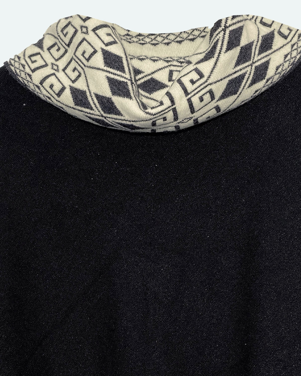 Detalle del cuello alto del poncho Lluvia Nocturna con rombos y grecas en crema y negro
