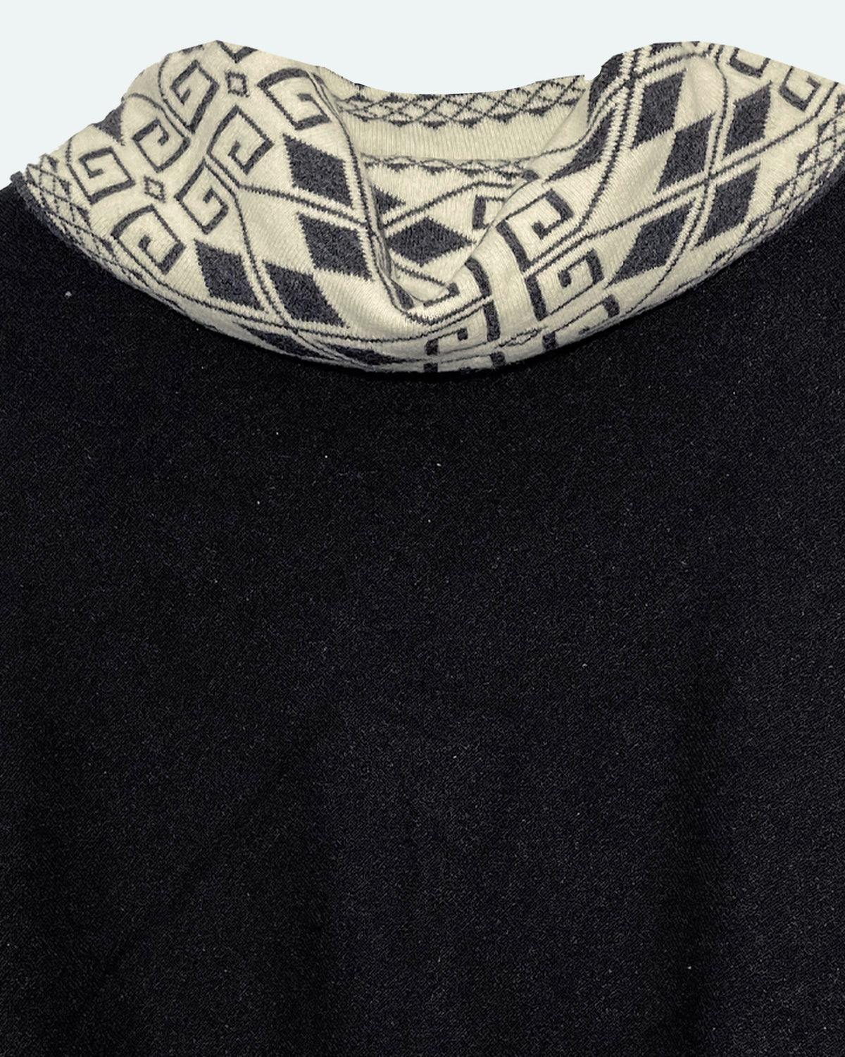 Detalle del cuello alto del poncho Lluvia Nocturna con rombos y grecas en crema y negro