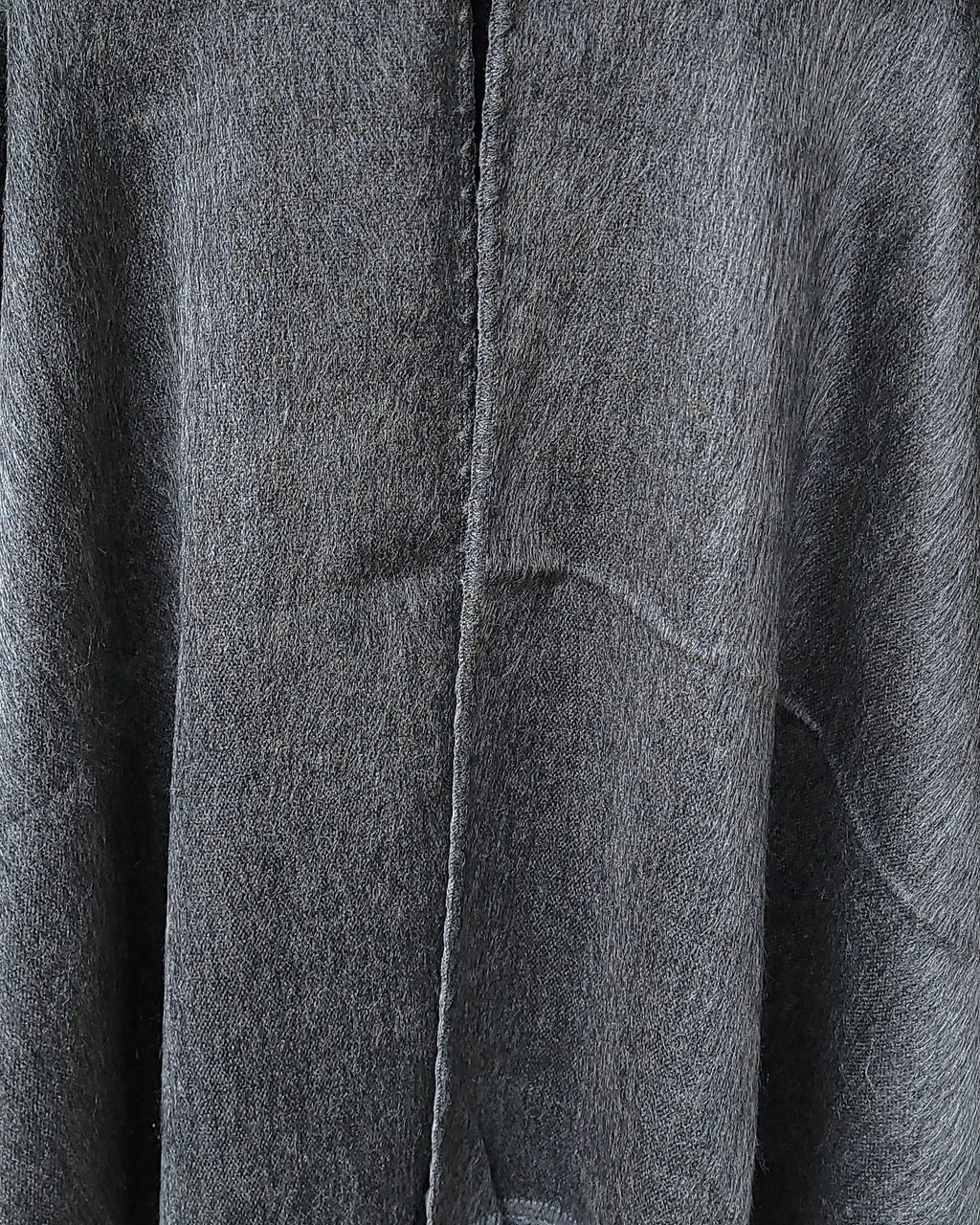 Detalle del tejido gris y la costura central del Poncho Sombra Andina