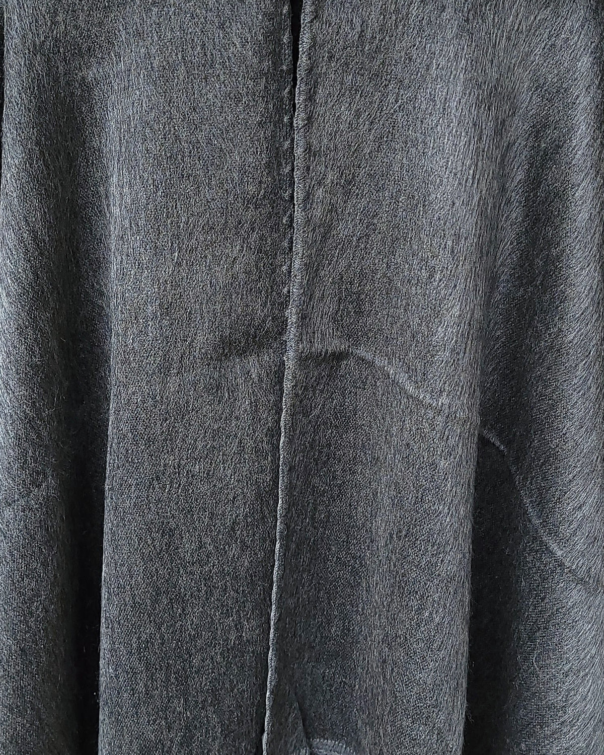 Detalle del tejido gris y la costura central del Poncho Sombra Andina