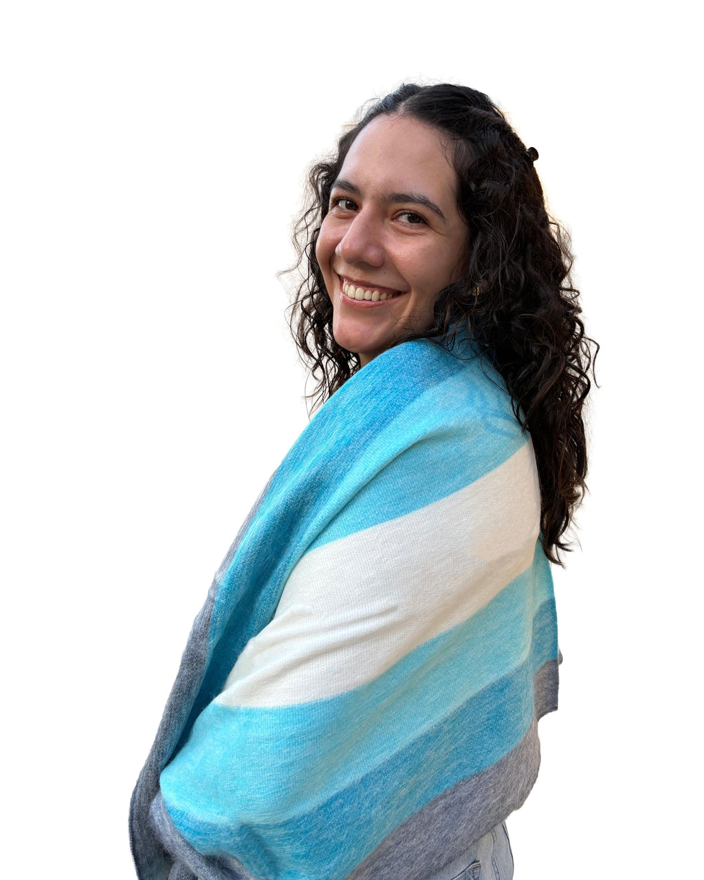 Chal de alpaca Bruma Azul en franjas celestes y marfil, sobre los hombros de una modelo sonriente de perfil
