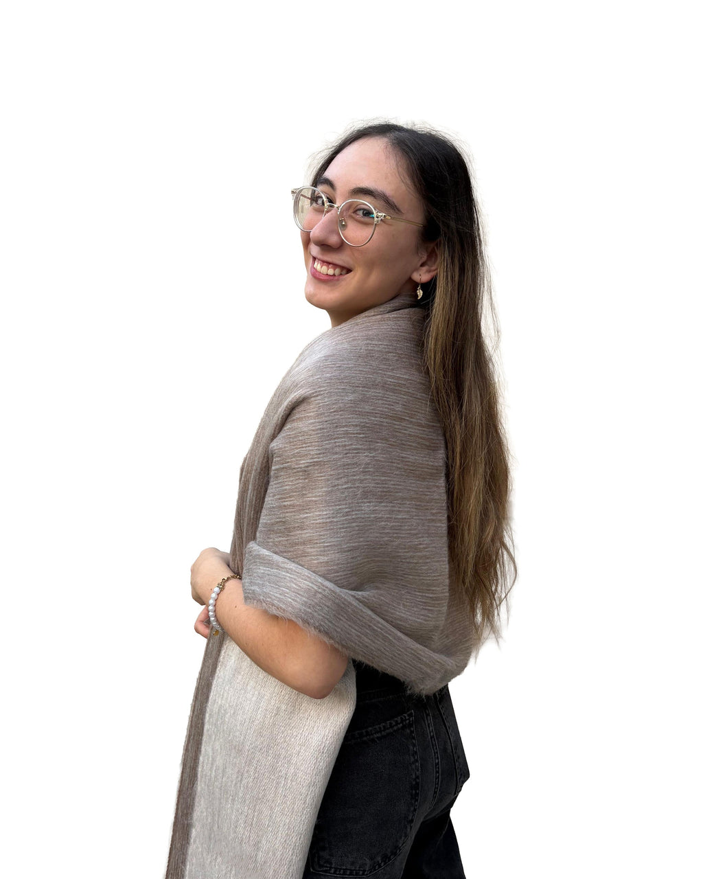 Chal de alpaca doble cara Arena en tonos beige, sobre los hombros de una modelo con lentes, vista de perfil