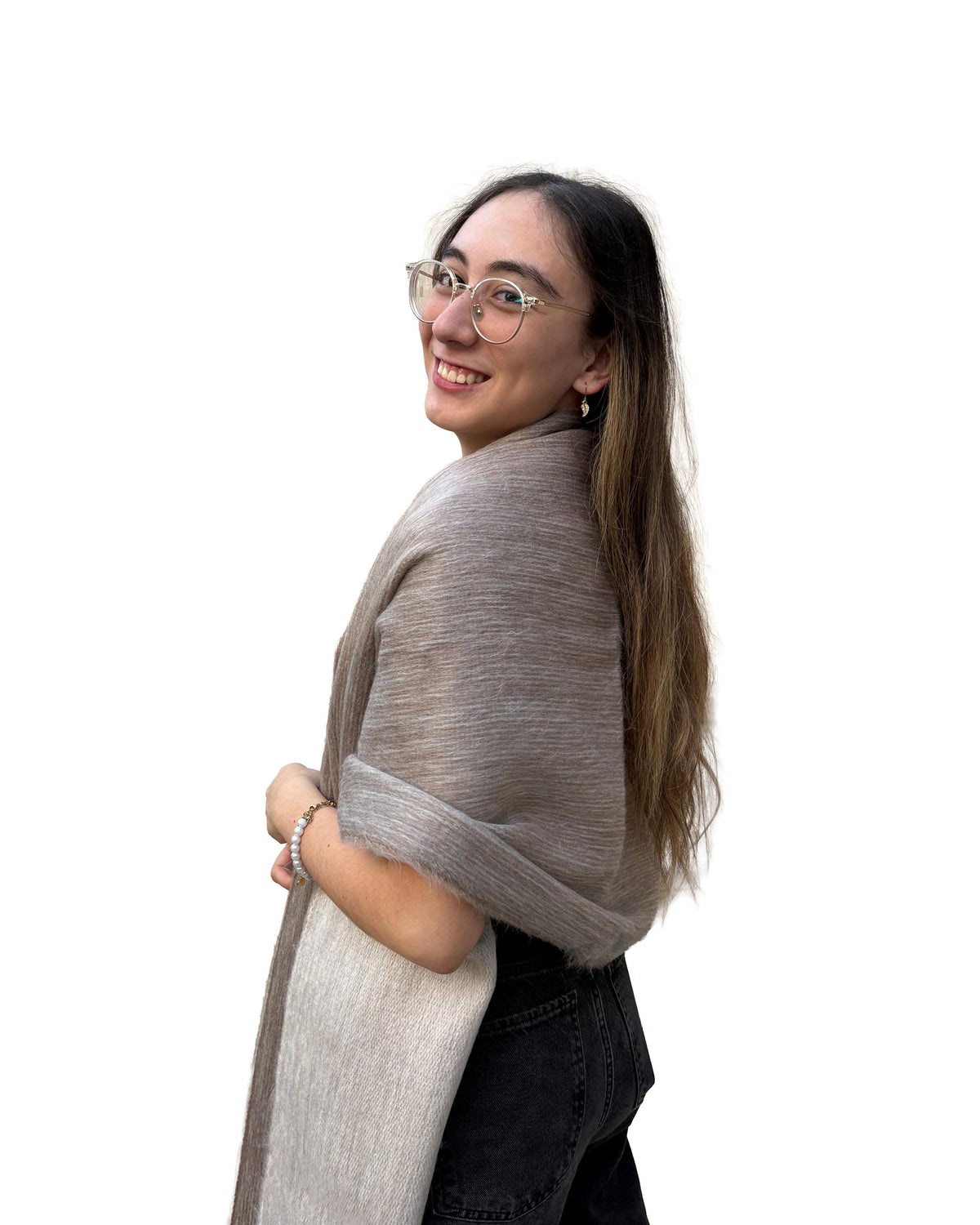 Chal de alpaca doble cara Arena en tonos beige, sobre los hombros de una modelo con lentes, vista de perfil