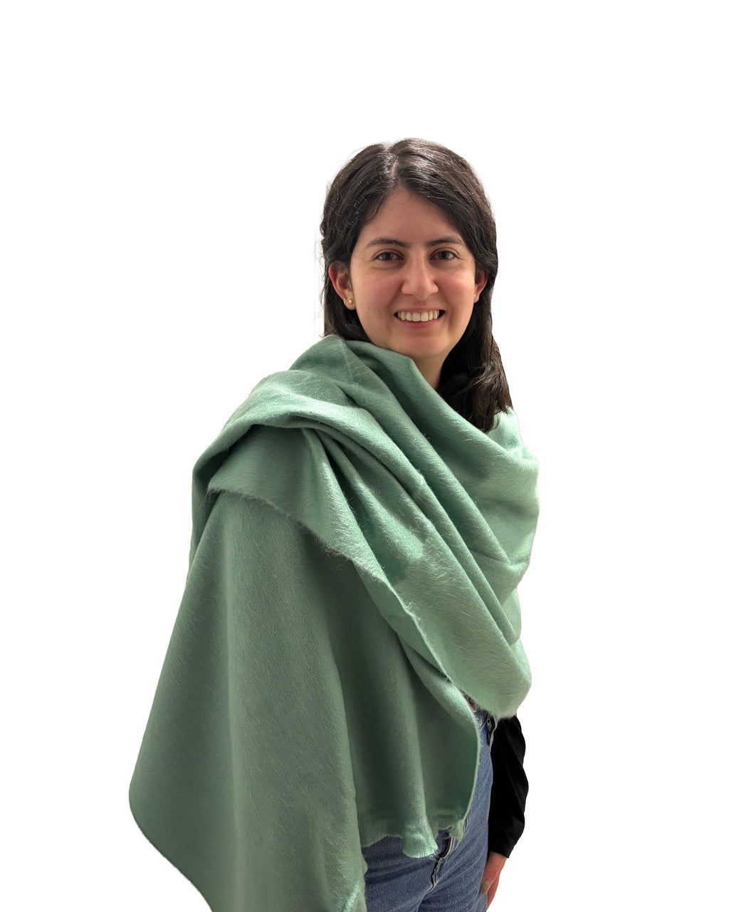 Chal de alpaca Menta Fresca en verde menta suave, puesto sobre los hombros de una modelo sonriente de pie