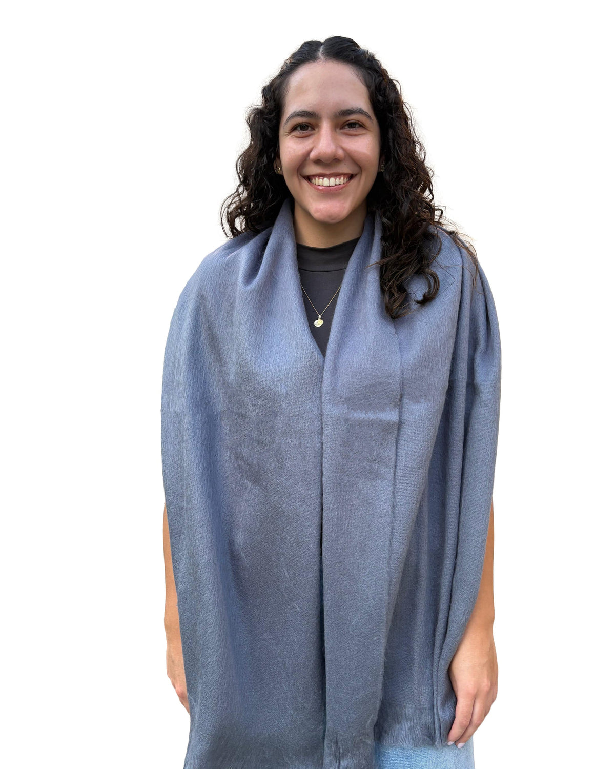 Chal de alpaca Humo Suave en gris azulado, sobre los hombros de una modelo sonriente, visto de frente